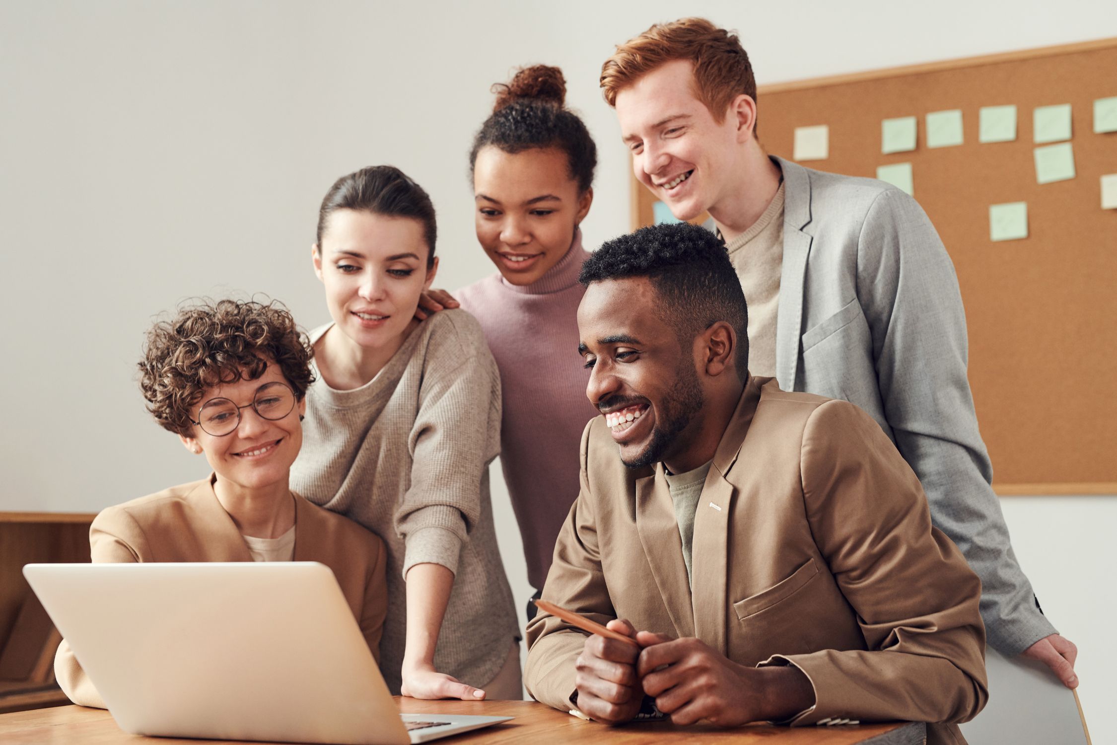 Cross-functional team collaborating around a shared screen, representing the convergence of product, analysis, and development roles