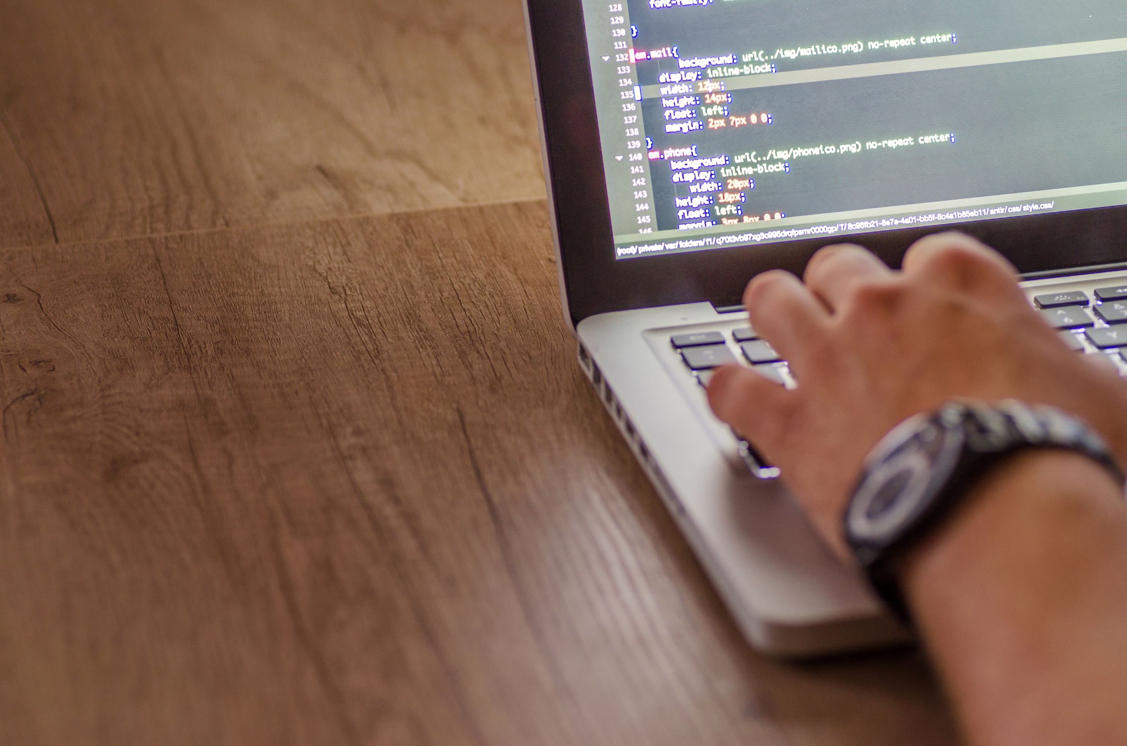 Developer using multiple monitors with code on screen